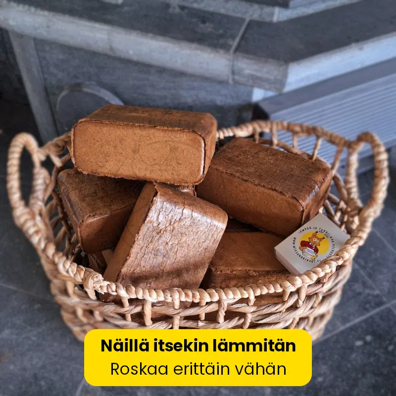 Briketti TUMMAT ja Miksun briksut -tulitikkuaski punotussa korissa takan vieressä. Polttopuuta valmiina takkaan.