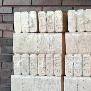 Puubriketti Tiilibriketti vaalea paketteja pinossa odottamassa siirtoa säilytykseen.